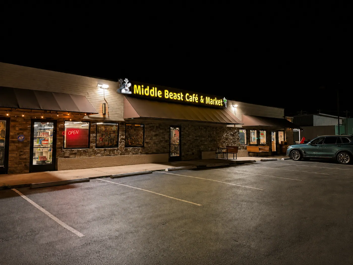 Middle Beast Cafe & Market storefront sign lit at night on West College Street